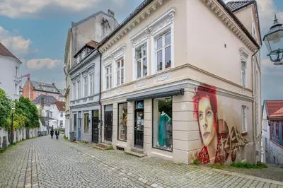 a street with a building with a mural of a woman at Charming apartment 200m from Bryggen in Bergen