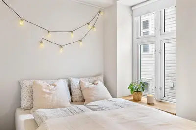 a bedroom with a bed and a window with lights at Charming apartment 200m from Bryggen in Bergen