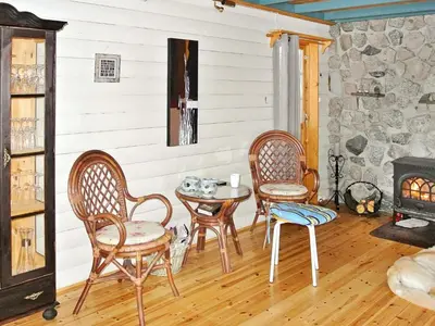 a room with chairs and a table and a fireplace at 11 person holiday home in Edland in Vågsli