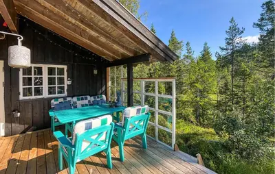 a wooden deck with a blue table and chairs at Cozy Home In Vinje With Wifi in Hommo