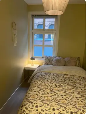 a bedroom with a bed with a large window at Unik og koselig leilighet midt i sentrum av Trondheim in Trondheim