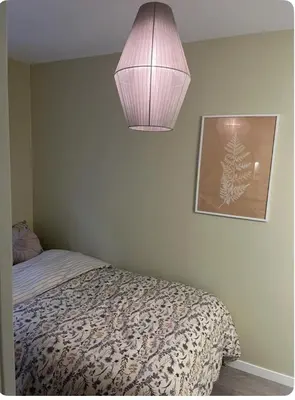 a bedroom with a bed and a light fixture at Unik og koselig leilighet midt i sentrum av Trondheim in Trondheim
