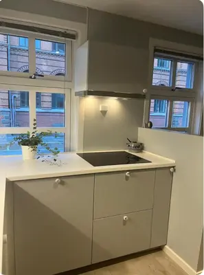 a kitchen with a stove and some windows at Unik og koselig leilighet midt i sentrum av Trondheim in Trondheim