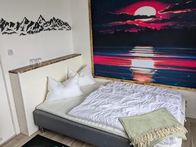 a bed in a room with a painting on the wall at Apartment Fjordblick in Leikanger