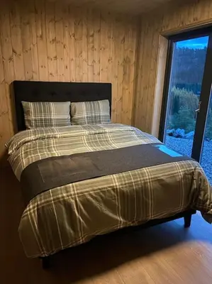 a large bed in a room with a window at Ny koselig hytte ved Sogn skisenter in Hafslo