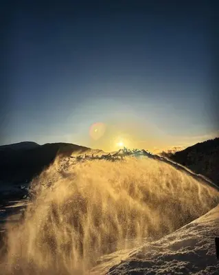 a wave in the water with the sun in the background at Ny koselig hytte ved Sogn skisenter in Hafslo