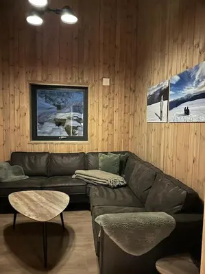 a living room with a leather couch and a table at Ny koselig hytte ved Sogn skisenter in Hafslo