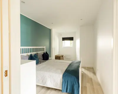 a bedroom with a bed in a white room at Vestre apartment in Ålesund