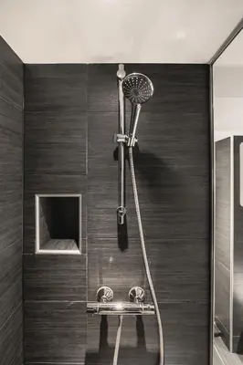 a shower in a bathroom with wooden walls and a shower at 500 m til Bryggen I Skjermet Uteplass! in Bergen