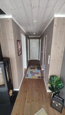 a hallway with a room with wooden floors and a door at Bjørkefinken by Norgesbooking - cabin for hiking and skiing in Tisleidalen