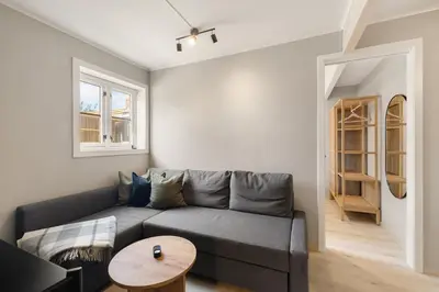 a living room with a gray couch and a table at Central and modern apartment in Trondheim