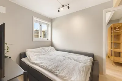 a bed in a room with a window at Central and modern apartment in Trondheim