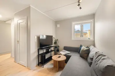 a living room with a couch and a table at Central and modern apartment in Trondheim