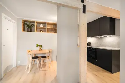 a kitchen with a small table and a kitchen with black cabinets at Central and modern apartment in Trondheim