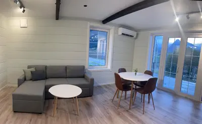 a living room with two tables and a couch at Husslåttene apartments with terrace in Skei