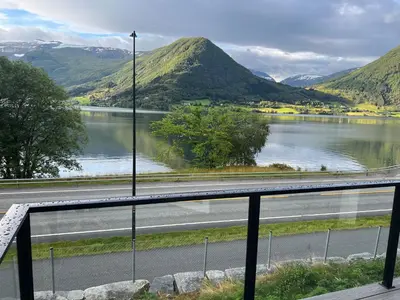 a view of a road and a river with mountains at Husslåttene apartments with terrace in Skei