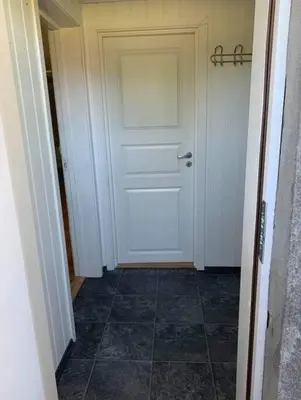 a hallway with a white door and a tile floor at Sokkel-leilighet med nærhet til sentrum og Hovden skiheis in Oppdal