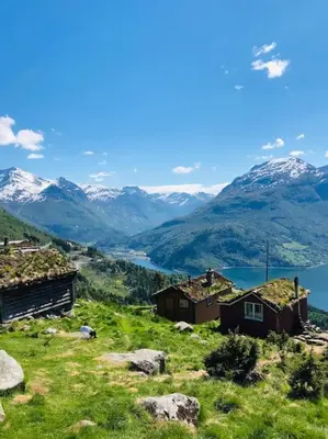 a view of a mountain with houses and a lake at Flat in the center of Loen in Loen