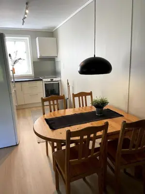 a kitchen with a wooden table with chairs and a dining room at Flat in the center of Loen in Loen