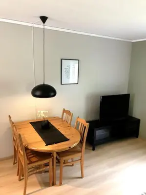 a dining room table with chairs and a black lamp at Flat in the center of Loen in Loen