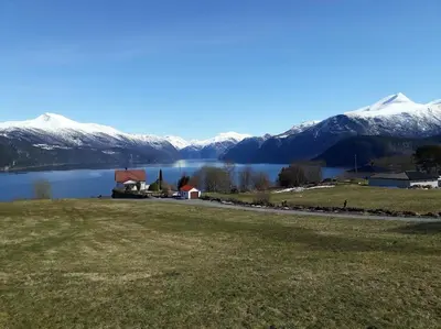 a view of a lake with snow covered mountains at Norwegian Fjords Time Out in Stranda