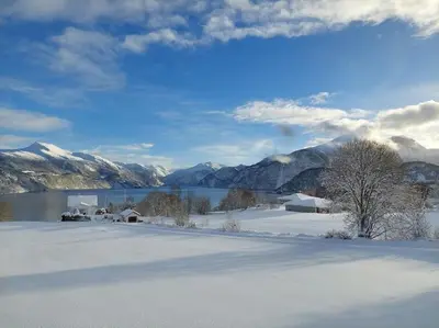 a snow covered field with a lake and mountains at Norwegian Fjords Time Out in Stranda