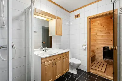 a bathroom with a sink and a toilet and a shower at Spacious cabin with a fabulous view and a sauna in Skulestadmo