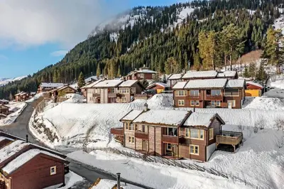 a village covered in snow with a mountain in the background at Spacious cabin with a fabulous view and a sauna in Skulestadmo