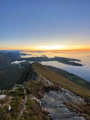 a view from the top of a mountain at sunset at Charming cabin retreat by the coast in Midsund in Midsund