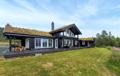 a large house with a large grass yard at Nice Home In Vinje With House Sea View in Trovatn