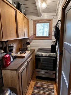 a small kitchen with a stove and a window at Hytta på Øyfjell in Trovatn