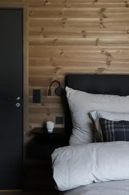 a bedroom with a bed with a wooden wall at New chalet with great view in Hafjell