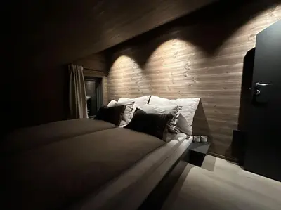 a bedroom with a bed with a wooden wall at New chalet with great view in Hafjell