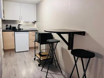 a small kitchen with a table and two stools at Sentralt beliggende studioleilighet in Gol