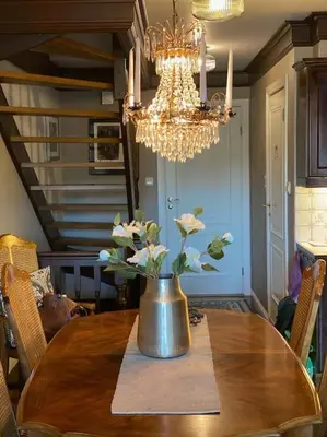 a dining room table with a vase of flowers on it at Toppleilighet Dr Holms in Geilo