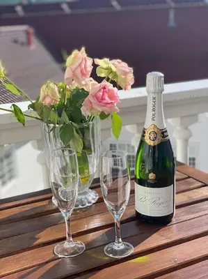 a bottle of champagne and two glasses on a table at Toppleilighet Dr Holms in Geilo