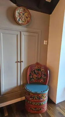 a chair in a room with a plate on the wall at Toppleilighet Dr Holms in Geilo