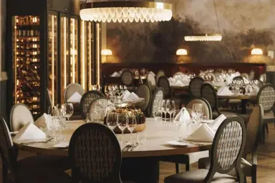 a dining room with tables and chairs with wine glasses at Toppleilighet Dr Holms in Geilo