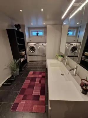 a bathroom with two washing machines and a sink at Hessahuset in Ålesund