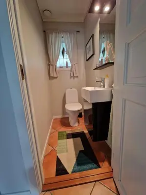 a bathroom with a toilet and a sink at Hessahuset in Ålesund
