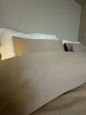 a bed with white sheets and pillows in a room at Leilighet i Bergens vakreste gate - Nydelig utsikt over innseilingen til Bergen! in Bergen