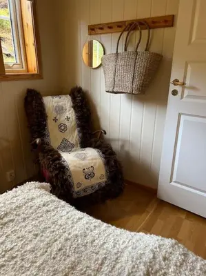 a living room with a chair and a door at Cozy apartement near Besseggen with a nice outdoor area! in Randsverk