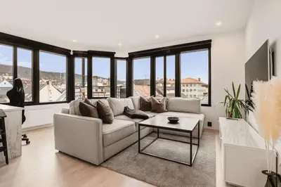 a living room with a couch and a table at Dinbnb Apartments I Penthouse 250m From City Center I Privat Balcony in Bergen