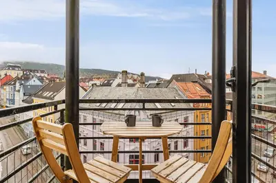 a table and chairs on a balcony with a view at Dinbnb Apartments I Penthouse 250m From City Center I Privat Balcony in Bergen