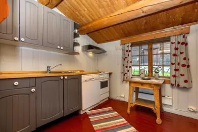 a kitchen with gray cabinets and a sink and a window at Frøy&Frøya Hyttetun in Skammestein