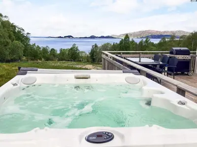 a hot tub with a view of the water at 9 person holiday home in Åram in Sandvik