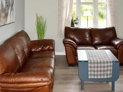 a living room with two leather couches and a table at 9 person holiday home in Åram in Sandvik