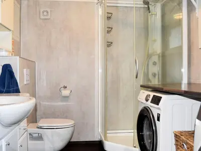 a bathroom with a shower and a washing machine at 9 person holiday home in Åram in Sandvik