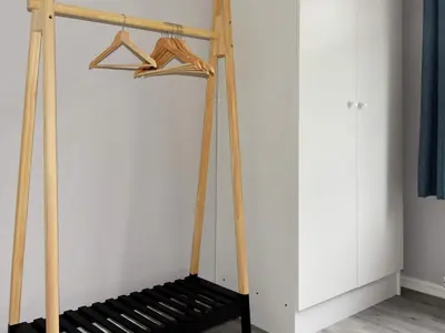 a wooden clothes rack with a bench in a room at 9 person holiday home in Åram in Sandvik