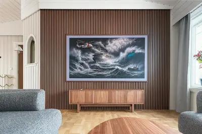 a painting of a ship in a wave on a wall at Hus med panoramutsikt i Bud in Bud